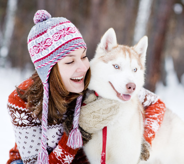 Junge Frau mit Hund im Schnee